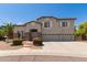 Charming two-story home featuring a three car garage, stone accents, and lovely landscaping at 4490 S Rio Dr, Chandler, AZ 85249