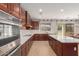 Open kitchen featuring a kitchen island, dark cabinets, and stainless steel appliances at 4490 S Rio Dr, Chandler, AZ 85249