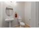 Cozy powder room featuring a pedestal sink, tiled floors, and traditional fixtures at 4490 S Rio Dr, Chandler, AZ 85249