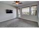 Comfortable bedroom featuring two windows with blinds, an access door to the balcony, and a mounted television at 4777 S Fulton Ranch Blvd # 1024, Chandler, AZ 85248