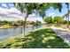Scenic community lake view, featuring a lush green lawn, walking path, and blue skies with scattered clouds at 4777 S Fulton Ranch Blvd # 1024, Chandler, AZ 85248