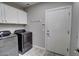 Laundry room featuring stainless steel washer and dryer, white cabinets, tile flooring and access door at 4777 S Fulton Ranch Blvd # 1024, Chandler, AZ 85248