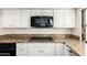 A close-up of the kitchen area featuring granite counters, a cooktop and white cabinets at 6313 E Aire Libre Ln, Scottsdale, AZ 85254