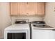 Laundry room with light wood cabinets and updated machines at 6313 E Aire Libre Ln, Scottsdale, AZ 85254