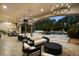 Elegant covered patio boasts stylish seating, chandeliers, and a serene pool view with fountain at 6852 E Fanfol Dr, Paradise Valley, AZ 85253