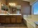 Bathroom with a large mirror, vanity, and soaking tub near the window at 703 E Taylor Trl, San Tan Valley, AZ 85143