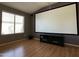 Home theater with a large screen, laminate flooring, and natural light from a nearby window at 703 E Taylor Trl, San Tan Valley, AZ 85143