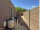 Side yard showing gravel landscaping, privacy wall, and necessary equipment to maintain the pool at 703 E Taylor Trl, San Tan Valley, AZ 85143