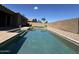 A refreshing swimming pool in backyard with artificial turf, stone vases and firepit at 703 E Taylor Trl, San Tan Valley, AZ 85143