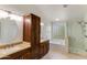 Bright bathroom with a tiled floor, a glass-enclosed shower, and double sinks with granite countertops at 7326 W Pershing Ave, Peoria, AZ 85381