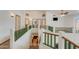 Upstairs hallway with green and brown railings, neutral walls, and multiple doorways, offering a view below at 7326 W Pershing Ave, Peoria, AZ 85381