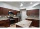 Modern kitchen with stainless steel appliances, dark cabinets, and a granite countertop at 7326 W Pershing Ave, Peoria, AZ 85381
