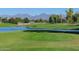 Scenic golf course view showcasing the vibrant green, a pond, tee box and mountains in the distance at 7350 N Via Paseo Del Sur -- # Q105, Scottsdale, AZ 85258