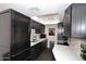 Well-lit kitchen with modern countertops, dark wood cabinets, stainless steel appliances and dark wood herringbone floors at 7350 N Via Paseo Del Sur -- # Q105, Scottsdale, AZ 85258