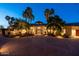 Elegant front exterior with lush landscaping, circular driveway, and arched entryways at 7801 N Saguaro Dr, Paradise Valley, AZ 85253
