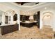 Spacious kitchen with dark wood cabinetry, large island, and high-end appliances for the discerning chef at 7801 N Saguaro Dr, Paradise Valley, AZ 85253