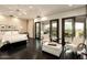 Luxurious main bedroom featuring a plush bed, seating area, and expansive views from sliding glass doors at 7801 N Saguaro Dr, Paradise Valley, AZ 85253