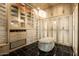 Elegant walk-in closet featuring custom shelving, mirrored doors, drawers, and a chic ottoman at 7801 N Saguaro Dr, Paradise Valley, AZ 85253
