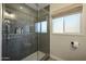 Close-up of a modern tile shower with a glass door, window, and shelf for bath products at 8132 E Valley View Rd, Scottsdale, AZ 85250