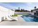 Relaxing backyard featuring a refreshing pool, artificial grass, and lounge chairs at 8132 E Valley View Rd, Scottsdale, AZ 85250