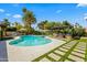 Sparkling pool and serene outdoor lounge with palm trees and lush landscaping against a blue sky at 8814 N 86Th St, Scottsdale, AZ 85258