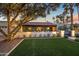 A well-manicured exterior featuring a spacious green lawn and a tree covered in lights at 8814 N 86Th St, Scottsdale, AZ 85258
