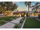 Charming home with a well-manicured lawn, elegant walkway, mature trees, and subtle exterior lighting at 8814 N 86Th St, Scottsdale, AZ 85258