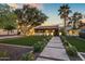 Exterior view showcases the tiled walkway, lawn, mature trees, and illuminated facade at 8814 N 86Th St, Scottsdale, AZ 85258