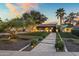 Beautiful home with a tidy lawn, stone pathway, mature trees with lights, and manicured landscaping at 8814 N 86Th St, Scottsdale, AZ 85258