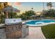 Pool view showcases a grill, manicured greenery, inviting seating, and striped umbrellas at 8814 N 86Th St, Scottsdale, AZ 85258