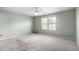 Spacious bedroom with a large window, ceiling fan, neutral paint color and plush carpet at 900 E Saratoga St, Gilbert, AZ 85296