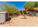 Backyard with a shed, retaining wall, and mature trees offering shade, plus a view of the main home at 9137 E Odessa St, Mesa, AZ 85207