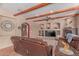 Comfortable living room with wooden beam ceilings, entertainment center, and cozy fireplace at 9137 E Odessa St, Mesa, AZ 85207