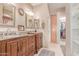 Double sink bathroom with beautiful wood cabinets, framed mirrors, and walk-in closet at 9137 E Odessa St, Mesa, AZ 85207