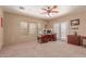 Well-lit office with large windows, wood desk, and neutral carpet, perfect for a home workspace at 9137 E Odessa St, Mesa, AZ 85207