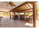 Spacious outdoor kitchen under covered patio with ceiling fans, seating, and bar, ideal for entertaining guests at 9137 E Odessa St, Mesa, AZ 85207
