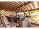 Spacious outdoor kitchen under covered patio with ceiling fans, seating, and bar, ideal for entertaining guests at 9137 E Odessa St, Mesa, AZ 85207