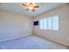 Bright bedroom featuring a ceiling fan, plush carpet, and a large window at 920 E Devonshire Ave # 4021, Phoenix, AZ 85014