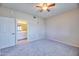 Spacious carpeted bedroom with a ceiling fan and an open doorway to the bathroom at 920 E Devonshire Ave # 4021, Phoenix, AZ 85014