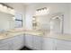 Double sink bathroom with white cabinets, plenty of counter space, and lots of lighting at 9705 E Mountain View Rd # 1050, Scottsdale, AZ 85258