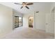 Spacious bedroom features neutral carpeting, a fan, access to balcony, and en suite bath at 9705 E Mountain View Rd # 1050, Scottsdale, AZ 85258
