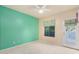 Bright bedroom with a teal accent wall, ceiling fan, neutral carpet, and outdoor access at 9750 N Monterey Dr # 21, Fountain Hills, AZ 85268