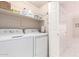 Bright laundry room with washer, dryer, wire shelving and white door to hallway at 9750 N Monterey Dr # 21, Fountain Hills, AZ 85268