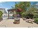 Outdoor kitchen features a grill, fire pit, mini-waterfall and seating area for entertaining next to a pool at 11021 N 64Th Ln, Glendale, AZ 85304