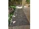 Elegant brick pathway connecting the lush, artificial grass area to the covered patio space at 11021 N 64Th Ln, Glendale, AZ 85304