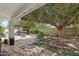 Large backyard with mature trees, a built-in fire pit, and ample space for outdoor activities at 11021 N 64Th Ln, Glendale, AZ 85304