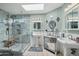 Bright bathroom featuring a stylish glass shower, double sinks, and a skylight for natural light at 11021 N 64Th Ln, Glendale, AZ 85304