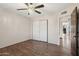 Simple bedroom with wood floors, a modern ceiling fan, and a spacious closet at 11021 N 64Th Ln, Glendale, AZ 85304