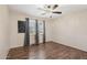 Cozy bedroom with wood floors, modern ceiling fan, and a bright window with shutters at 11021 N 64Th Ln, Glendale, AZ 85304