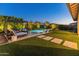 This backyard has a beautiful pool, outdoor dining, lounge chairs, and tasteful landscaping at 11705 W Luxton Ln, Avondale, AZ 85323